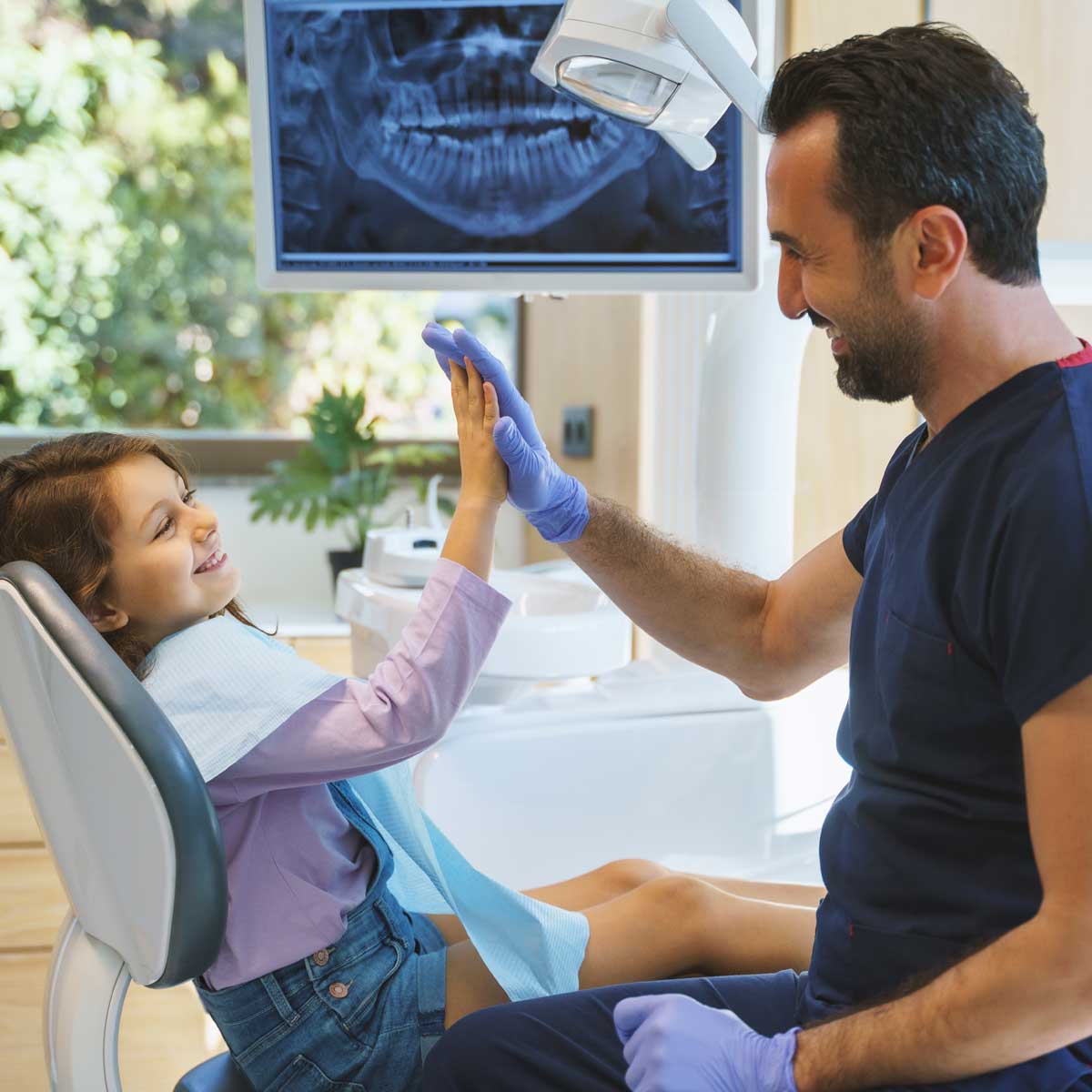 little girl giving high five to the dentist