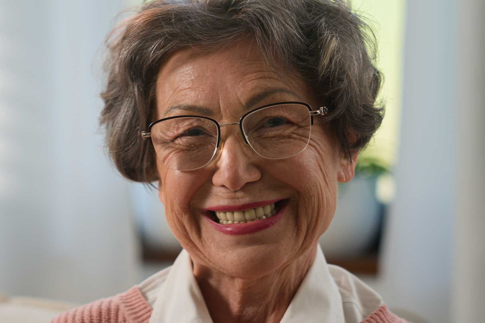 Old lady showing her dental implants through her smile