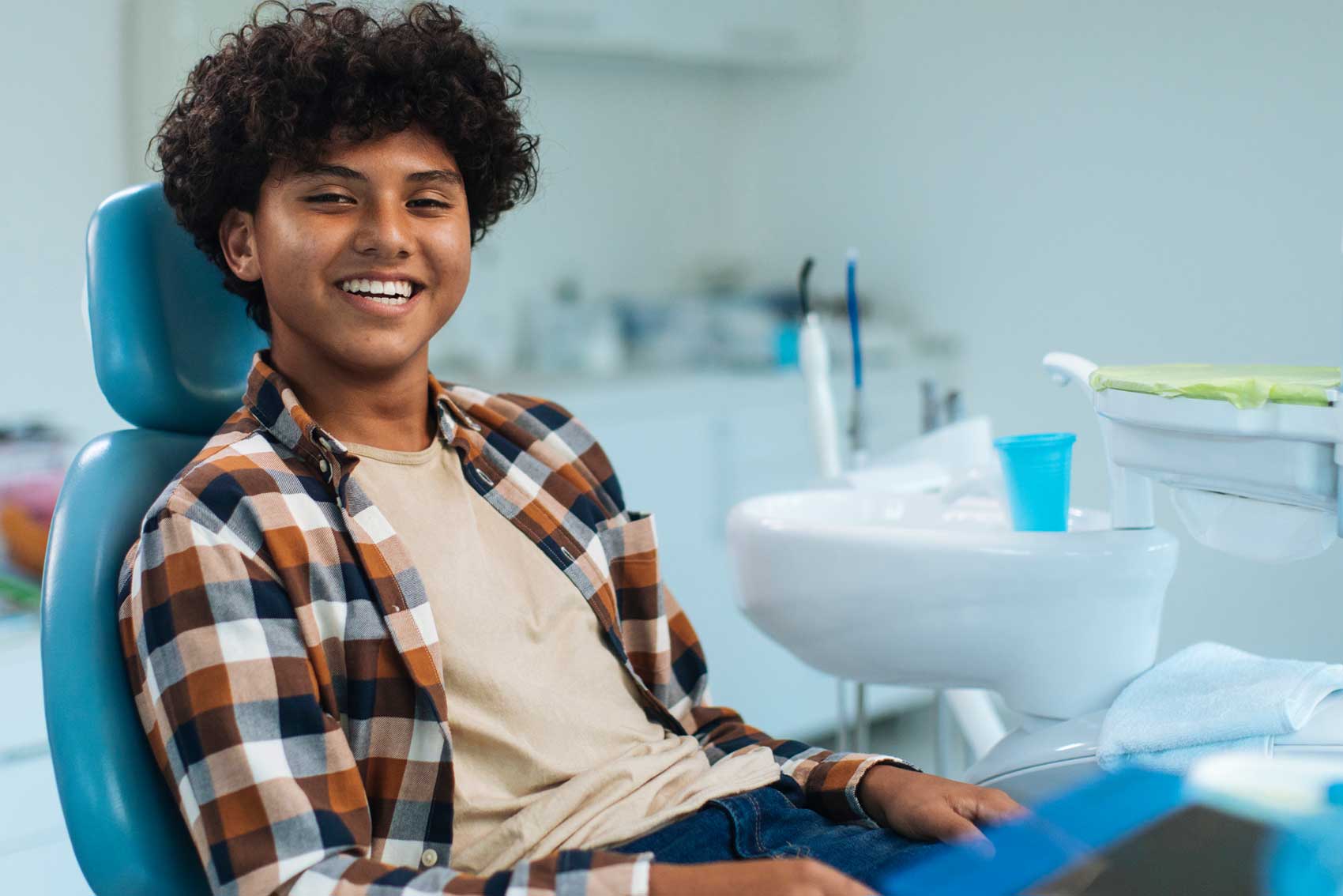 Teenager smiling while sat for general dentist treatment